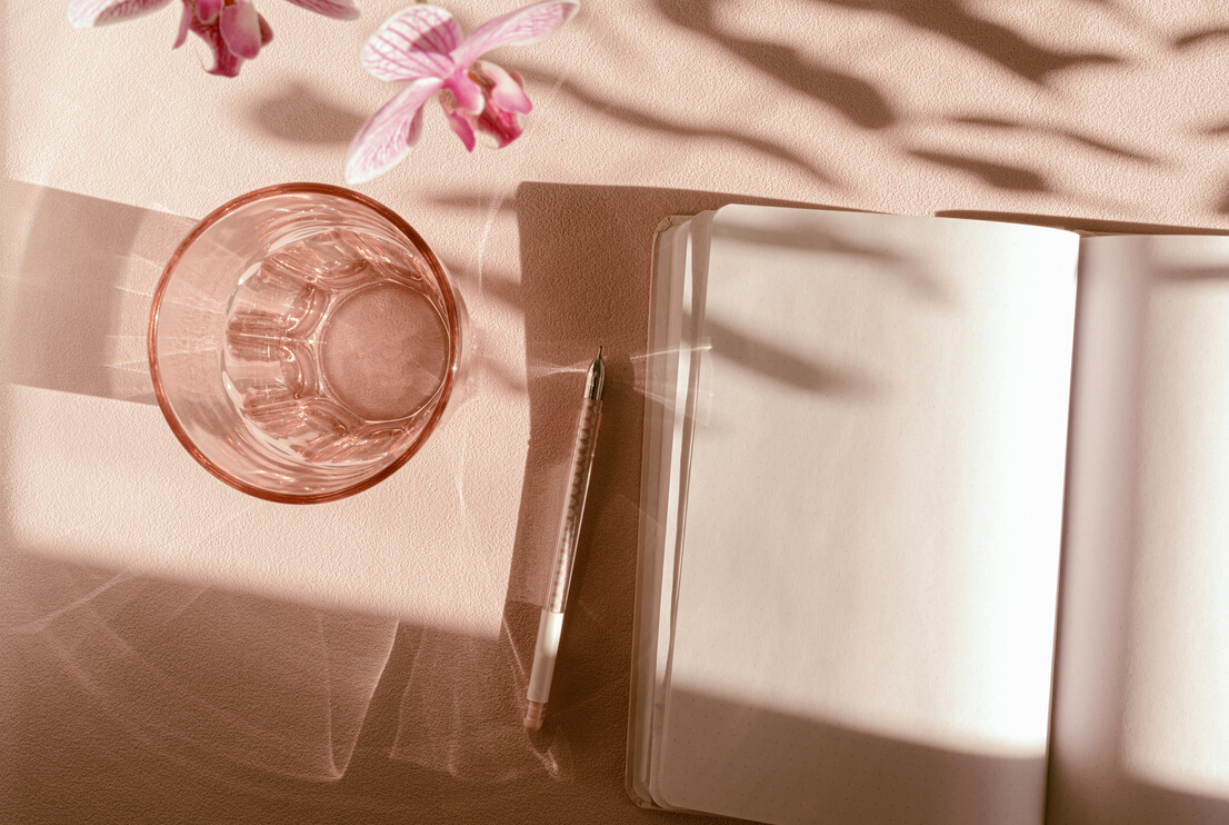 Spring aesthetic table scene with open journal, beige and pink pastels